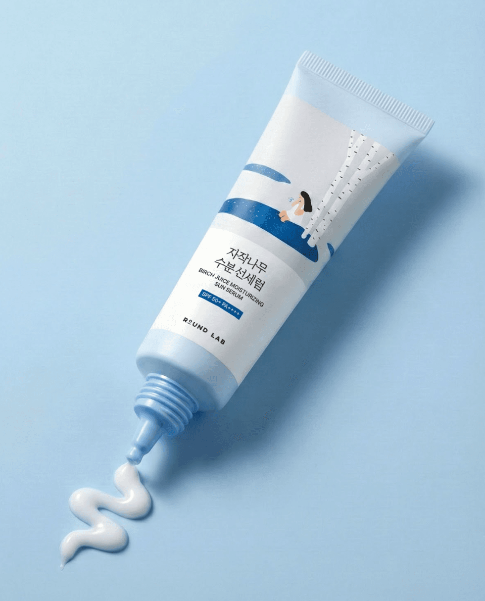 Tube of birch juice moisturizing sun serum on blue background, cream visible.