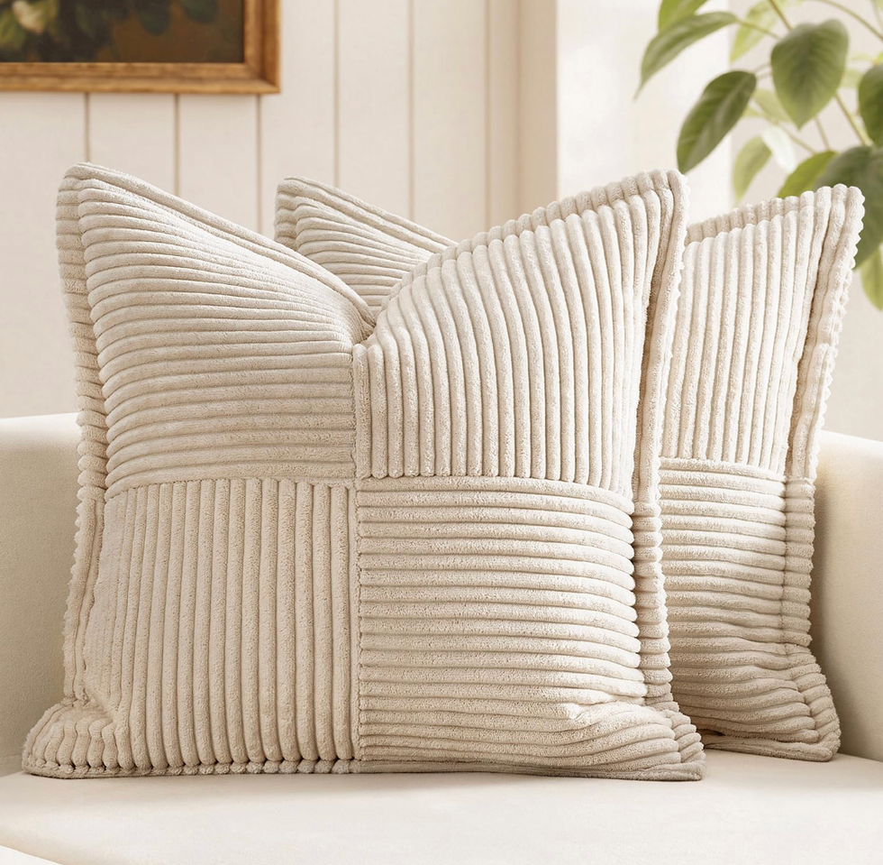 Two beige textured pillows on a light couch in a cozy room.