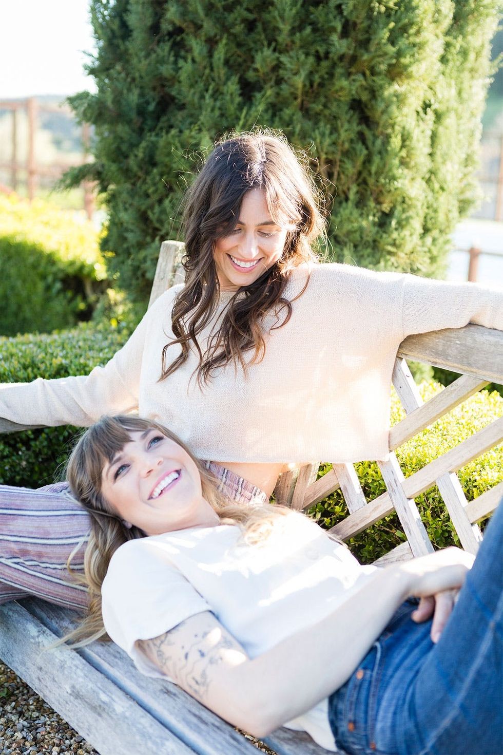 two friends hanging out outside on a park bench international women's day