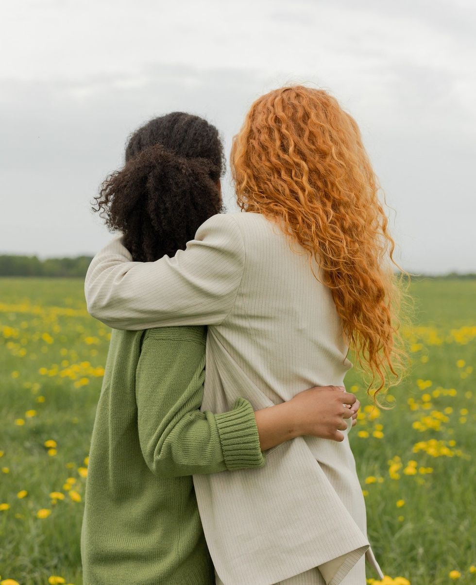 two friends hugging in a field