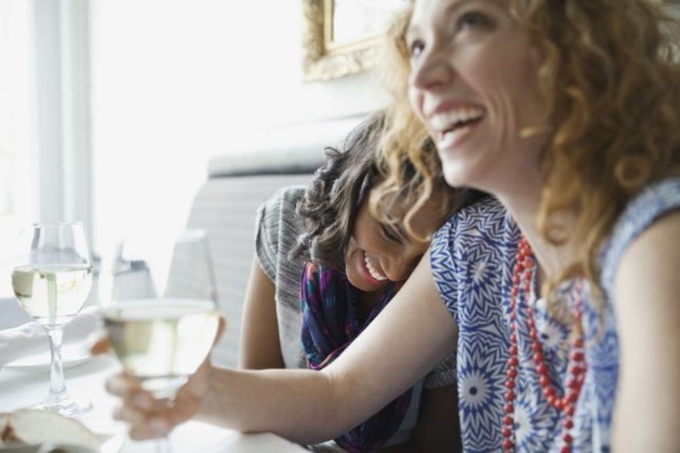 Two friends laugh together in a restaurant