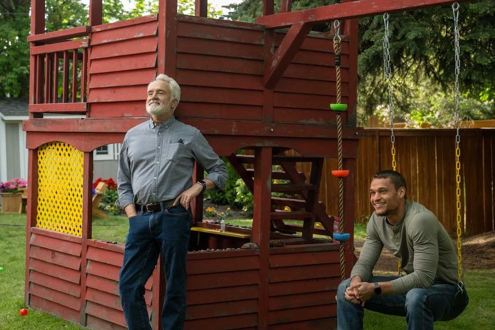 two guys hanging out on a swingset