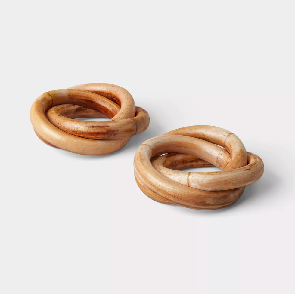 Two intertwined wooden rings on a white background.