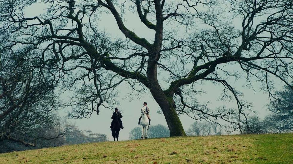 two men riding horses through the countryside