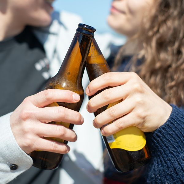 two people cheering their beers