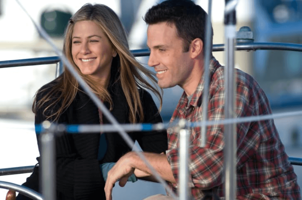 Two people smiling on a boat, enjoying a sunny day.