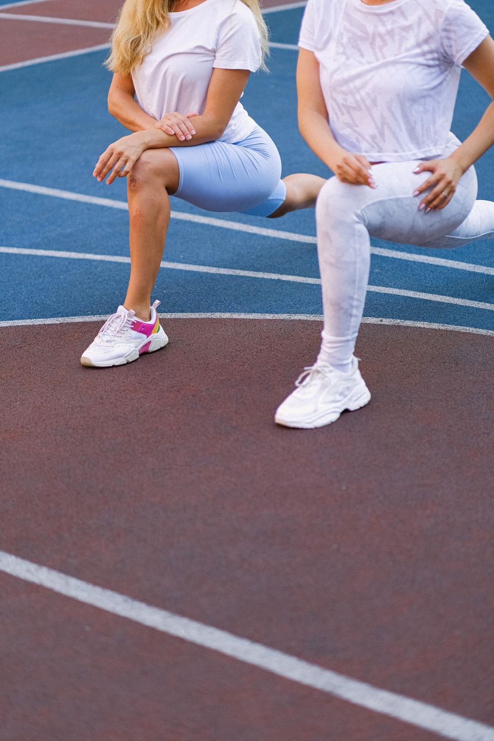 two people stretching on a track