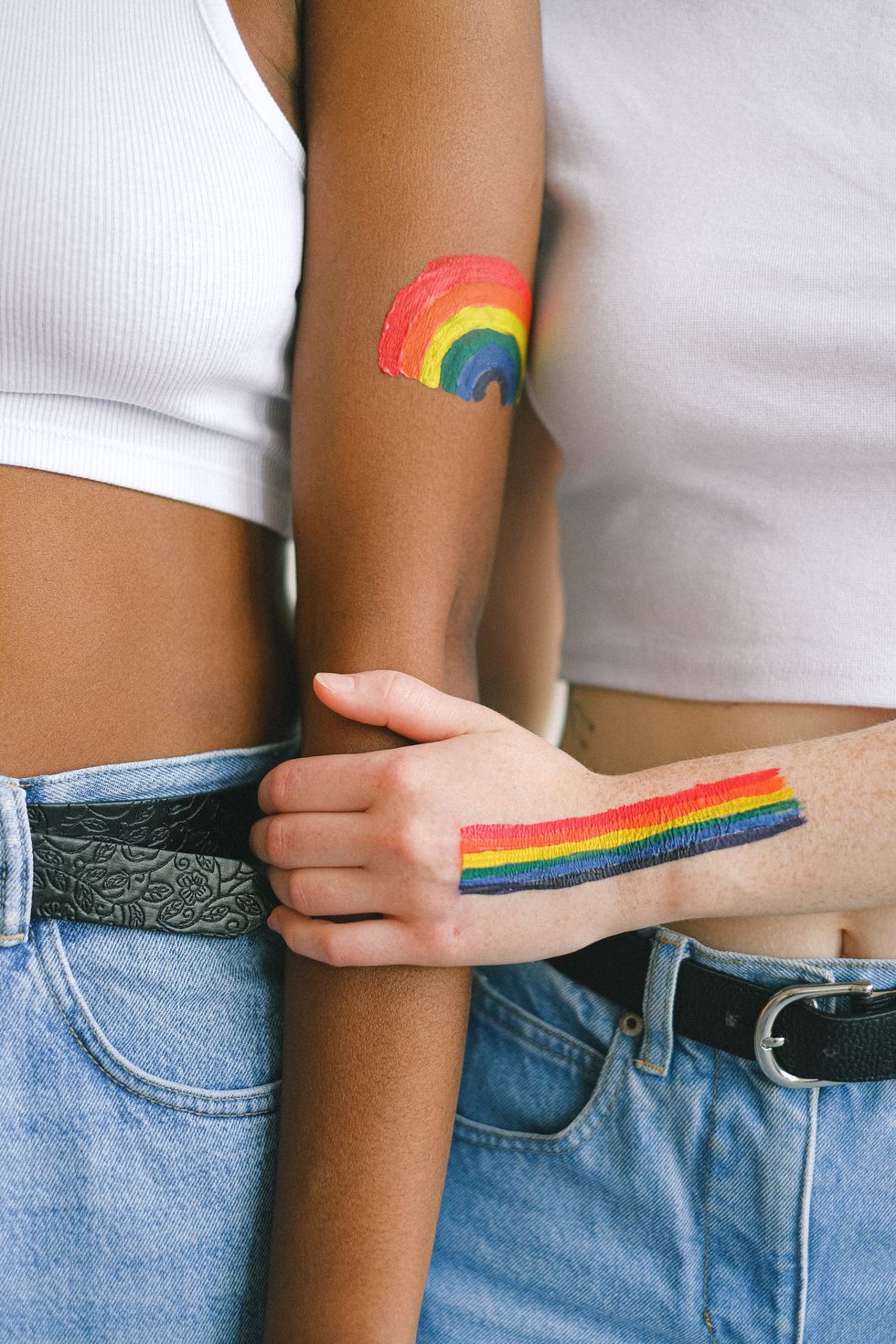 two people with gay pride body paint holding each other