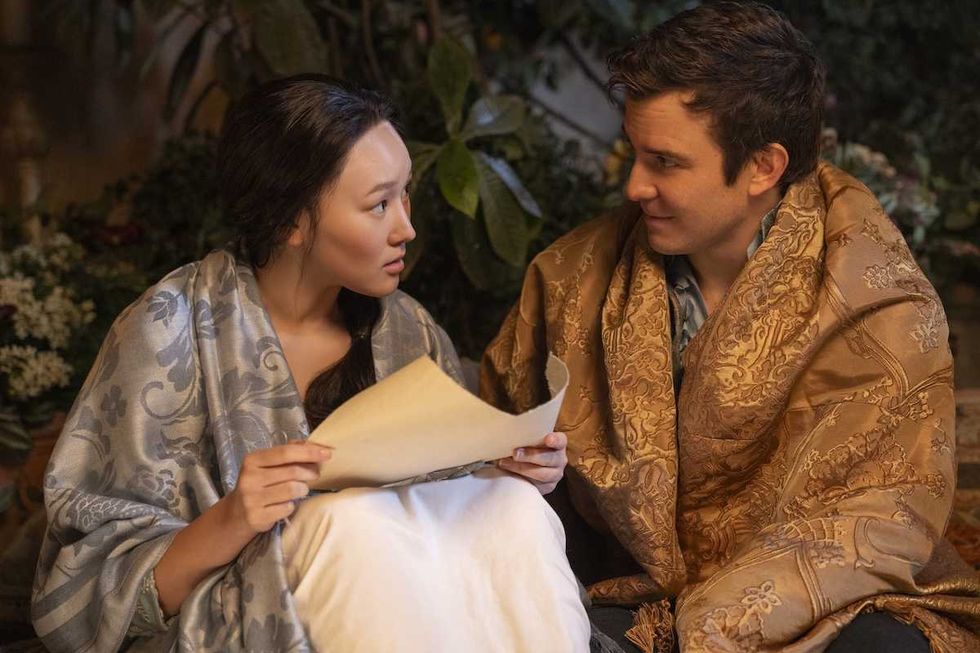 Two people, wrapped in blankets, share a thoughtful conversation outdoors. yerin ha interview bridgerton