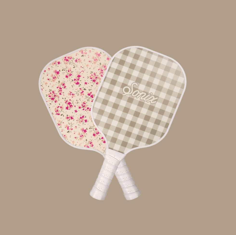 Two pickleball paddles with floral and plaid designs against a beige background.