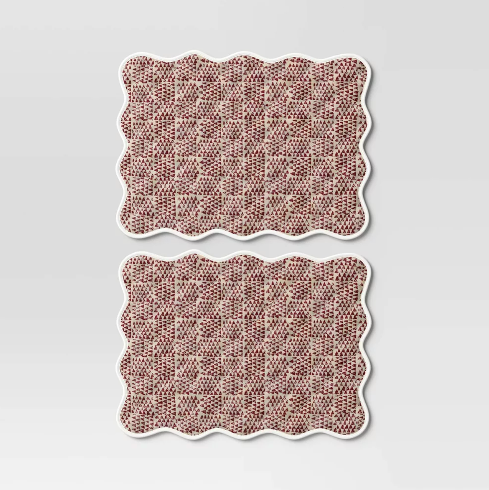 Two scalloped rectangular mats with a red and beige checkered pattern.