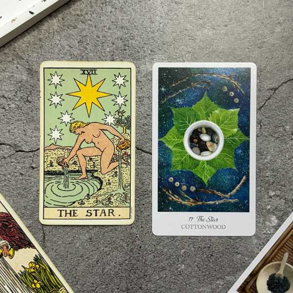 Two tarot cards, both "The Star," on a gray surface.