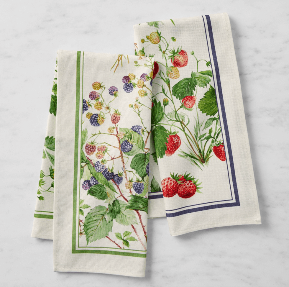 Two white napkins with illustrations of berries and green foliage.
