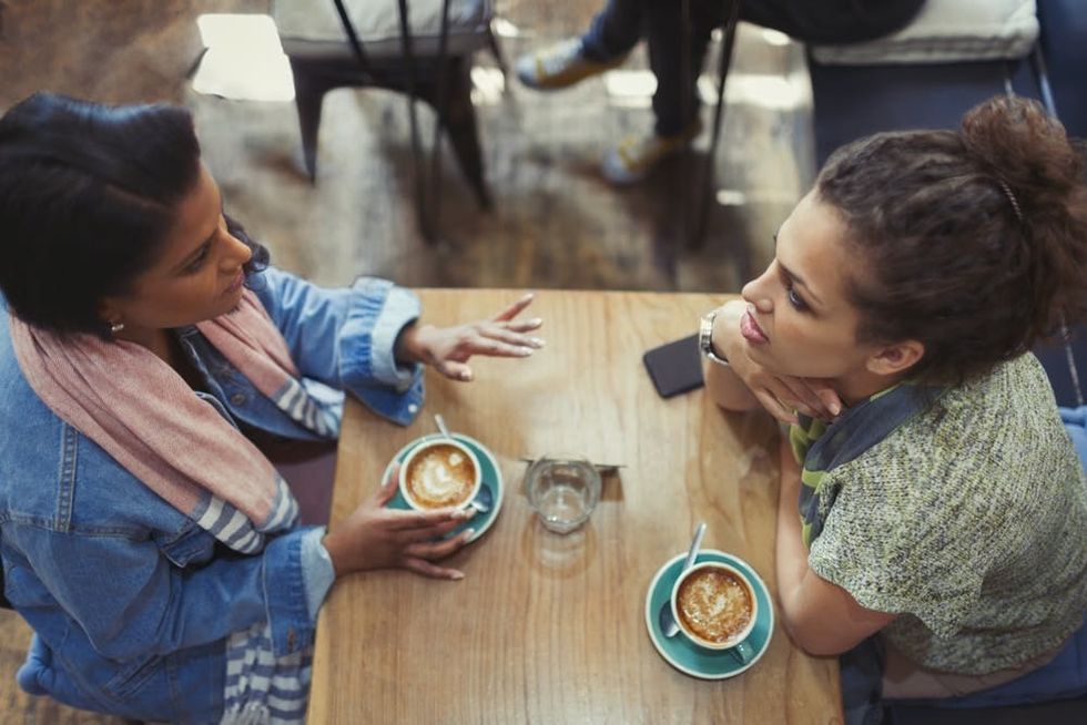 Two women chat over coffee