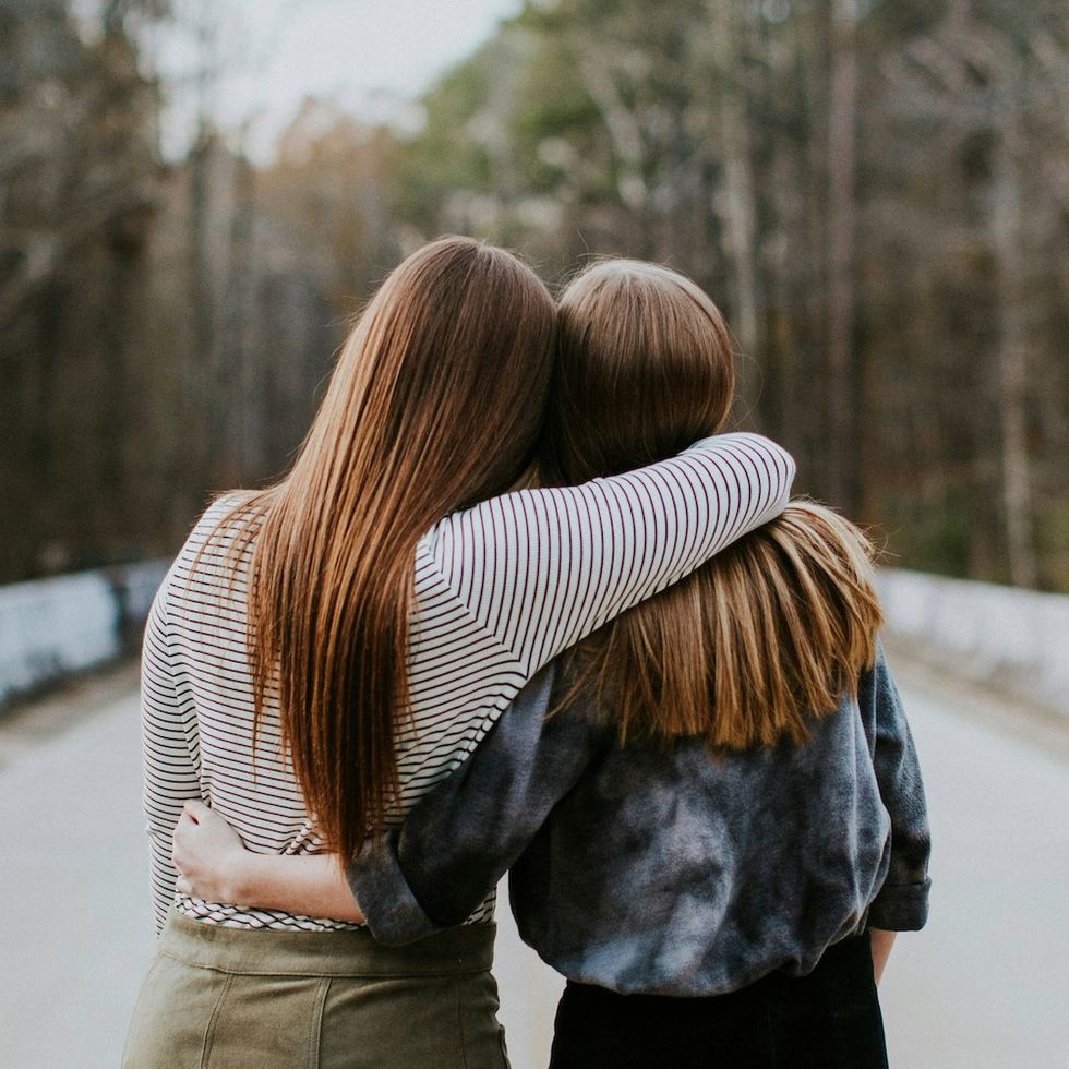 two women hugging with their backs to the camera