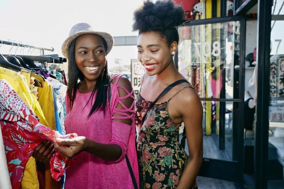 Two women look at clothes on a rack outside a store