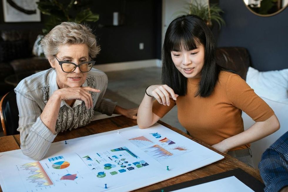 two women looking over a work presentation