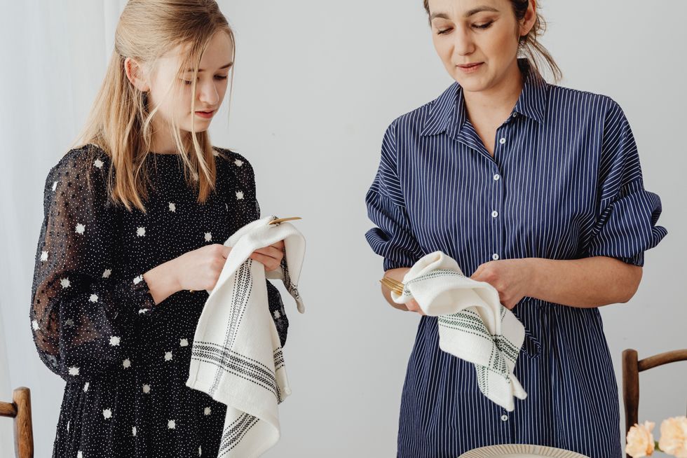 two women wiping off sliverware cleaning for the sunday reset