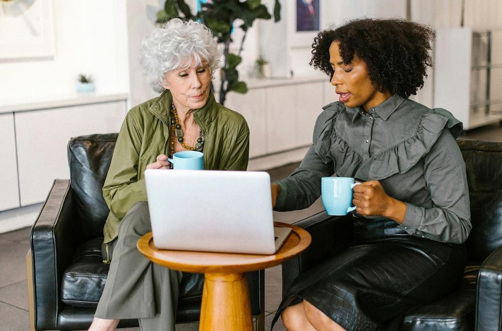 two women working on a laptop together in the office