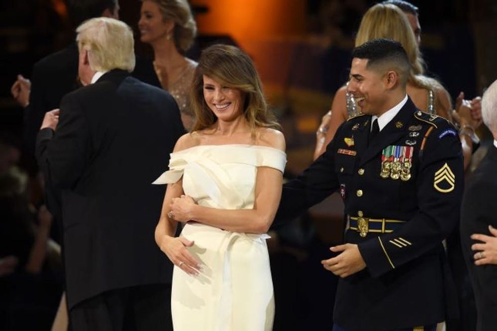 US First Lady Melania Trump (C) dances with a member of the Marine Corps (R) during the Salute to Our Armed Services Inaugural Ball at the National Building Museum in Washington, DC, January 20, 2017. / AFP / SAUL LOEB (Photo credit should read SAUL LOEB/AFP/Getty Images)