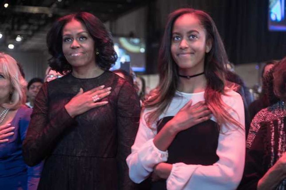 US First Lady Michelle Obama (L) and daughter Malia listen to the national anthem before President Barack Obama delivered his farewell address in Chicago, Illinois on January 10, 2017. Barack Obama closes the book on his presidency, with a farewell speech in Chicago that will try to lift supporters shaken by Donald Trump's shock election. / AFP / NICHOLAS KAMM (Photo credit should read NICHOLAS KAMM/AFP/Getty Images)