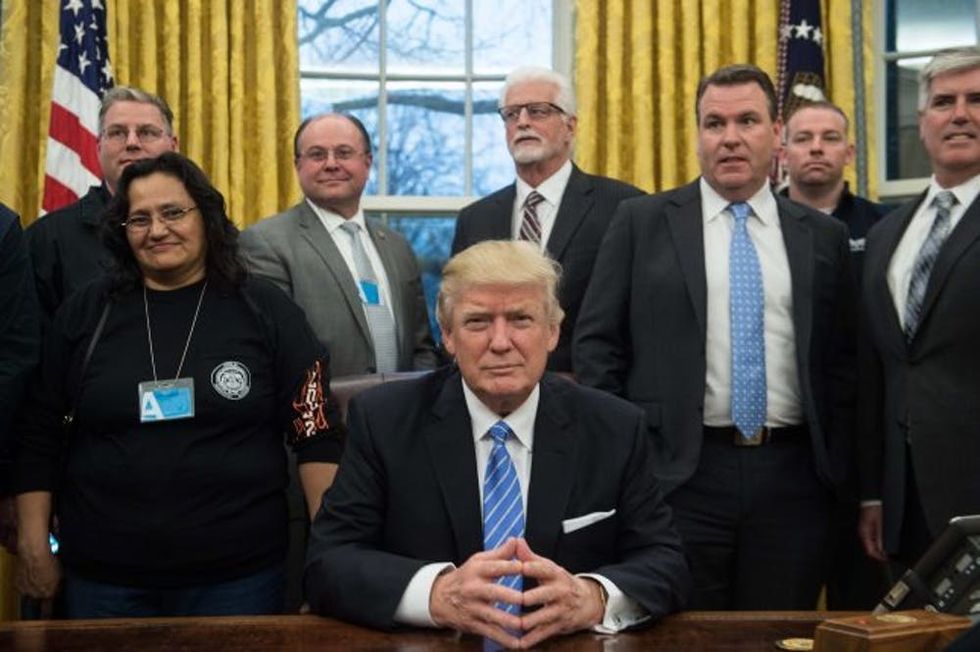 US President Donald Trump poses with labor leaders on January 23, 2017 in the Oval Office at the White House in Washington, DC. / AFP / NICHOLAS KAMM (Photo credit should read NICHOLAS KAMM/AFP/Getty Images)