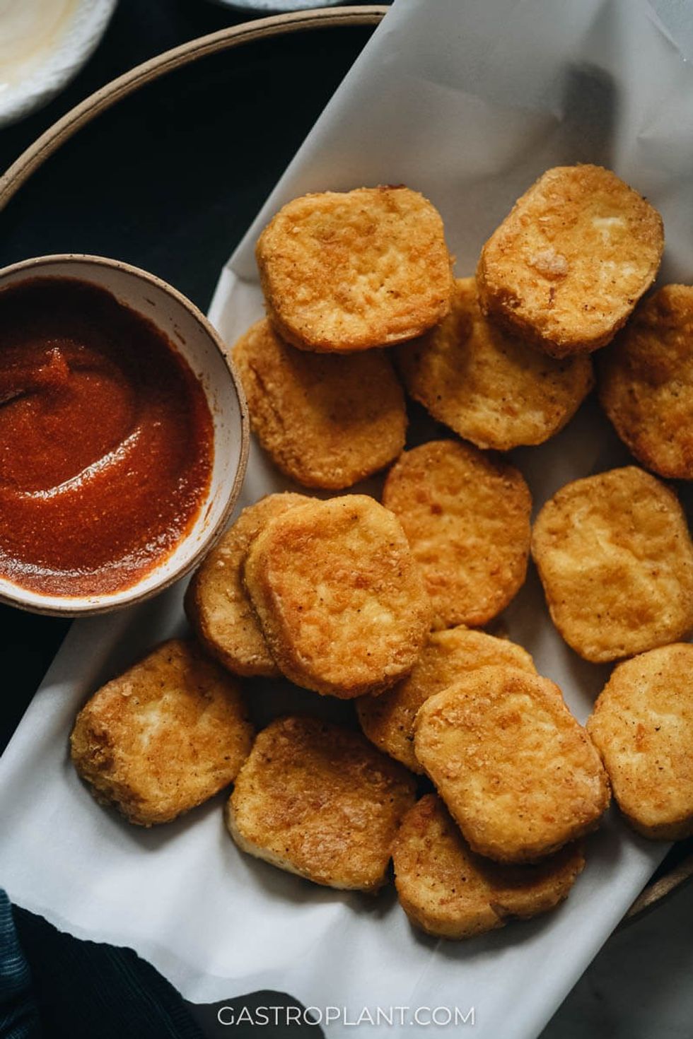 Vegan chicken nuggets are with a bowl of ketchup.