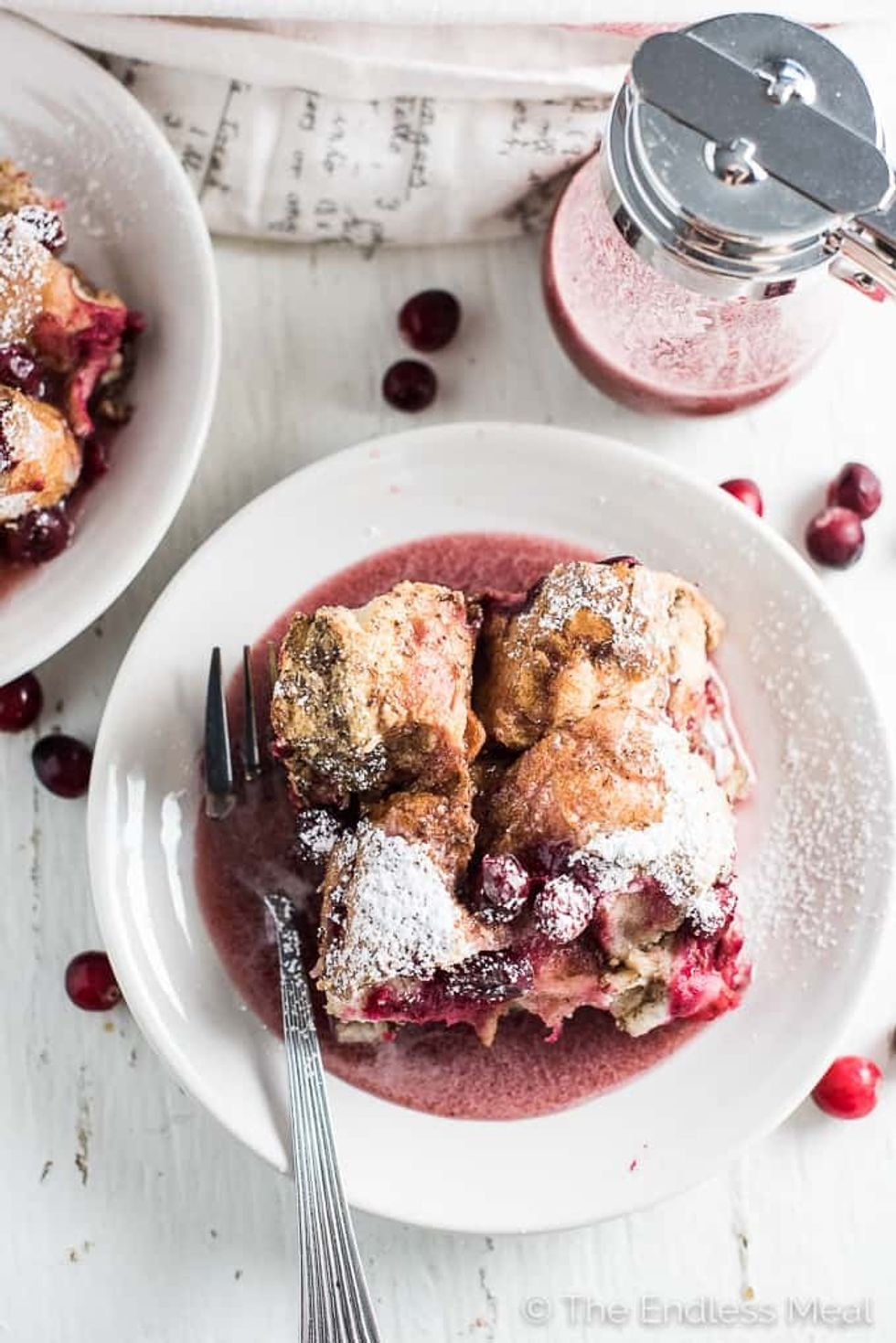 Vegan french toast sits in a white bowl with a fork.