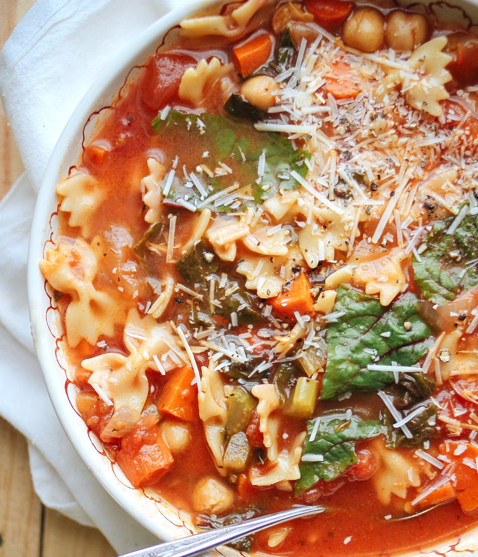 Vegetable and pasta soup with spinach and parmesan in a bowl.