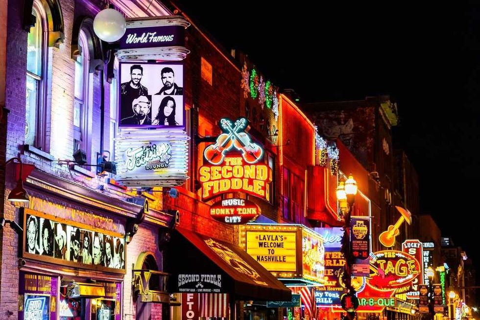 Vibrant neon signs and lights on a lively Nashville street at night.