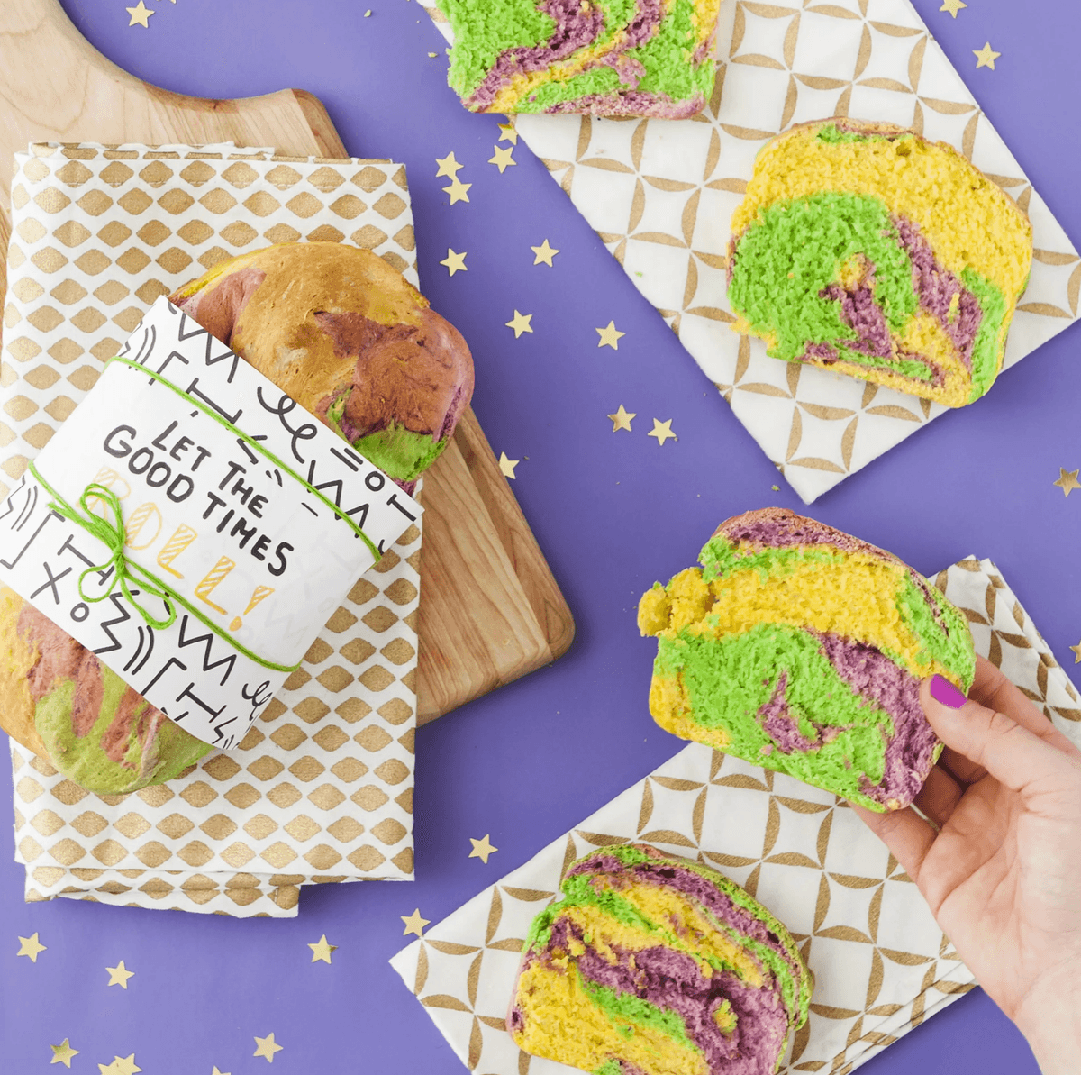 Vibrant swirled bread slices on purple background with stars, a hand holding one slice.