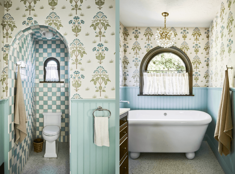 Vintage-style bathroom with floral wallpaper and arched windows, featuring a tub and toilet.