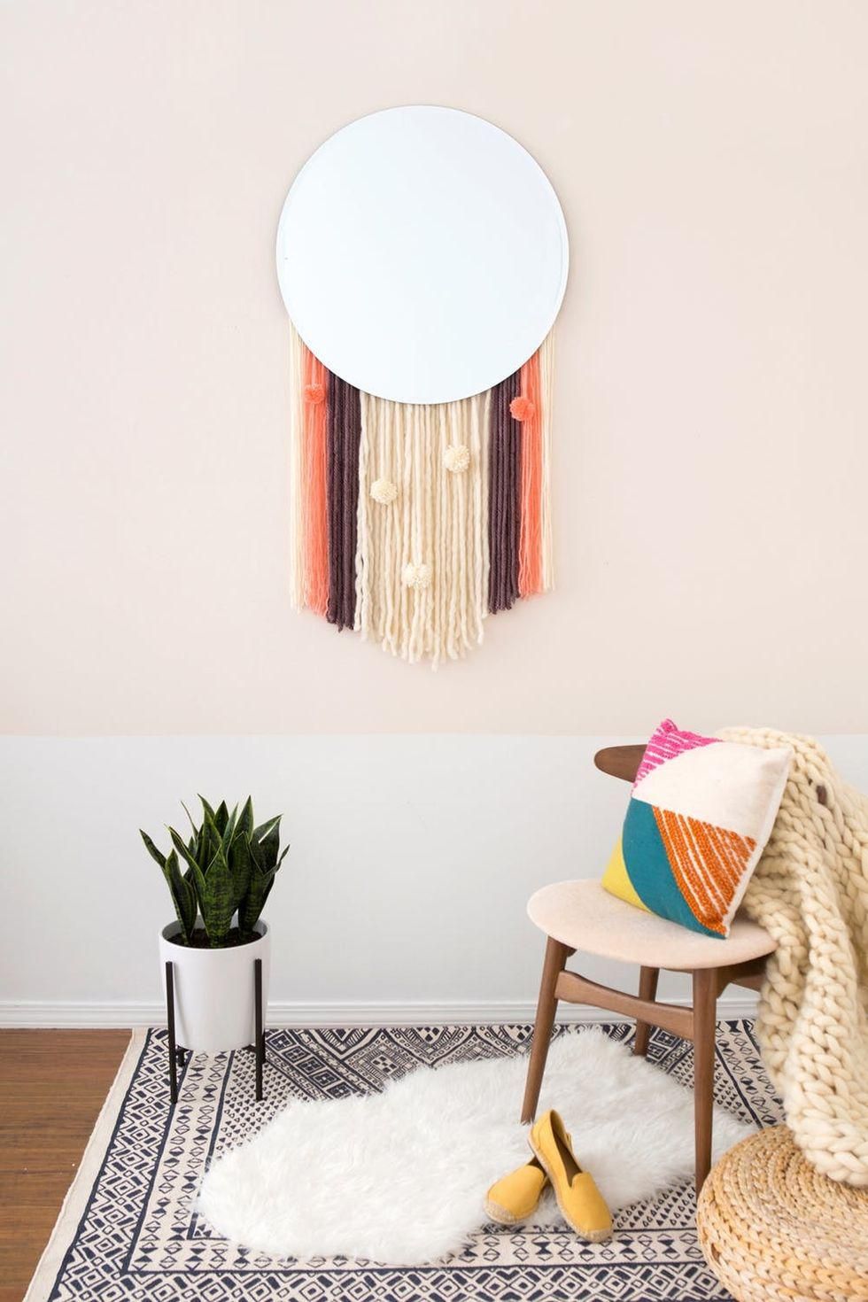 wall hanging mirror with a floor plant and a chair with a pillow
