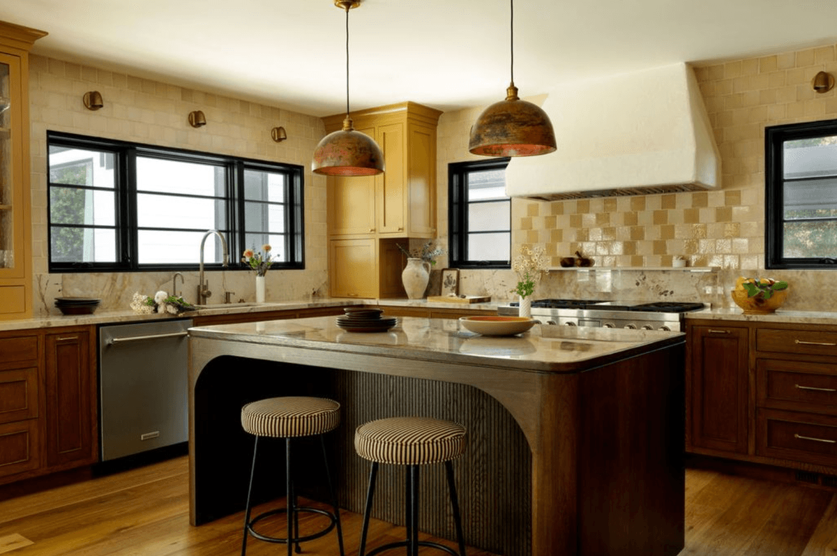 Warm, rustic kitchen with wood cabinets, island, two pendant lights, and modern appliances.