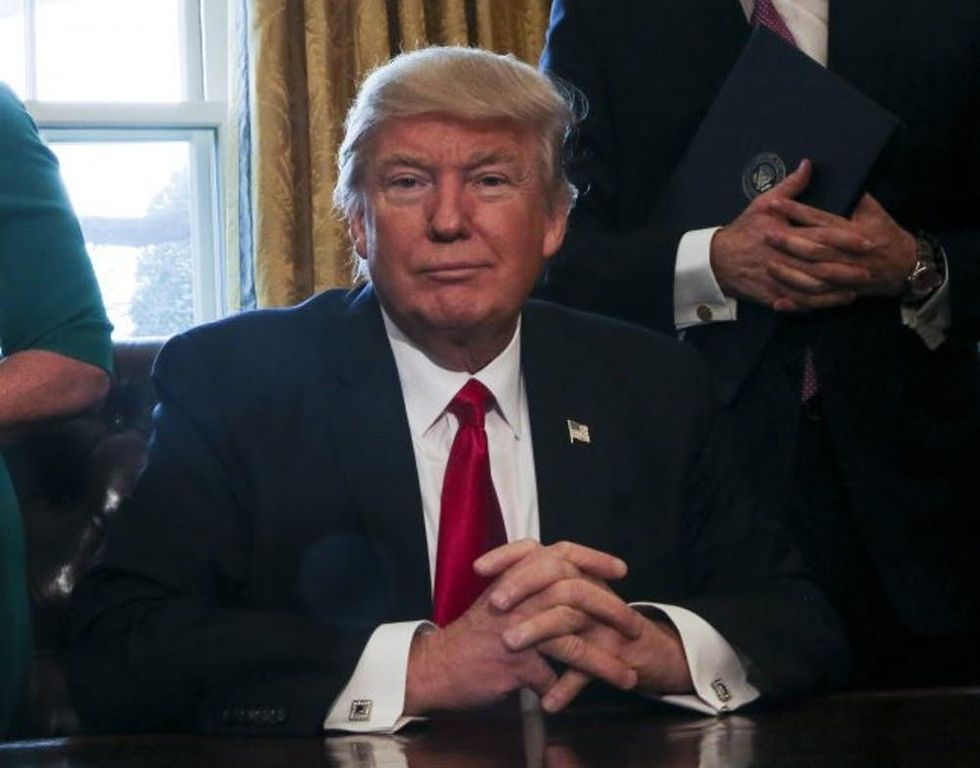 WASHINGTON, DC - FEBRUARY 3: (AFP OUT) U.S. President Donald Trump pauses while signning Executive Orders in the Oval Office of the White House, including an order to review the Dodd-Frank Wall Street to roll back financial regulations of the Obama era February 3, 2017 in Washington, DC. (Photo by Aude Guerrucci - Pool/Getty Images)