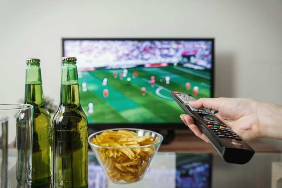 watching a football game with potato chips and two bottles