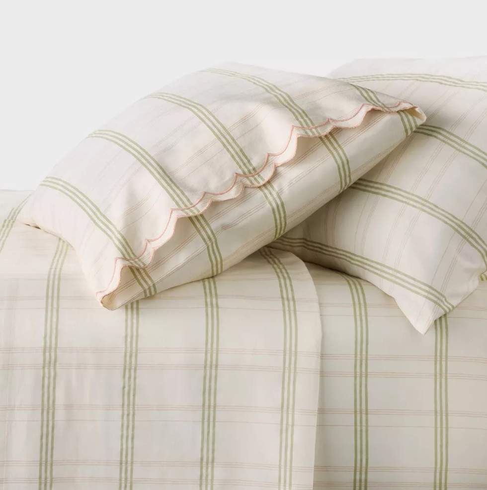 White and green plaid bedding with scalloped pillow edges.