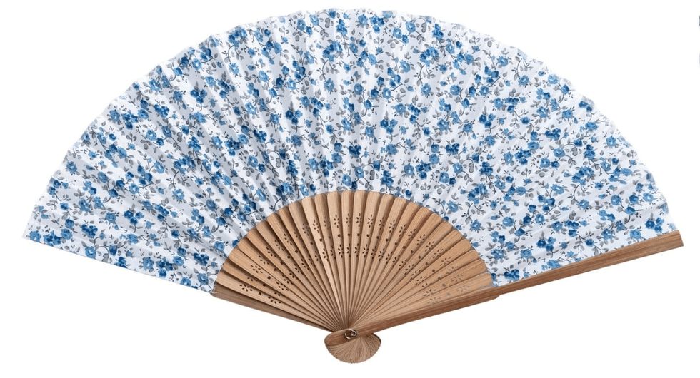 White hand fan with a blue floral pattern and wooden ribs.