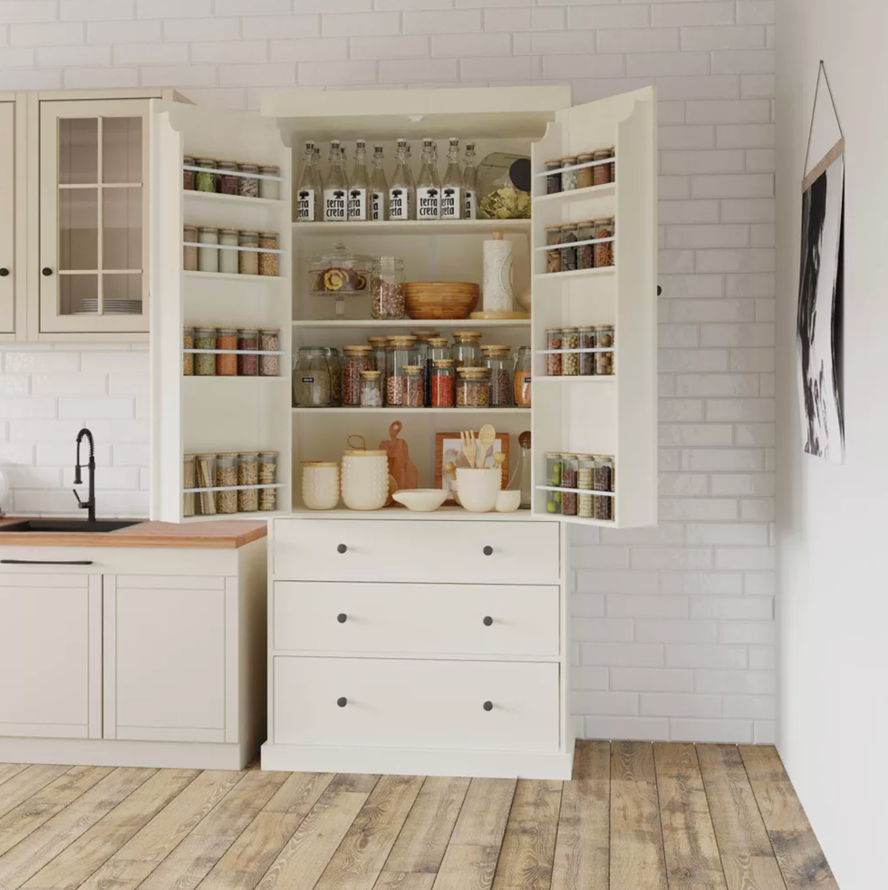 White kitchen pantry with open doors displaying jars and bottles organized on shelves.