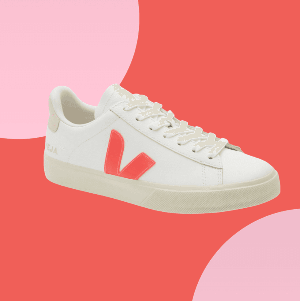 White sneaker with red "V" logo on a red and pink background.