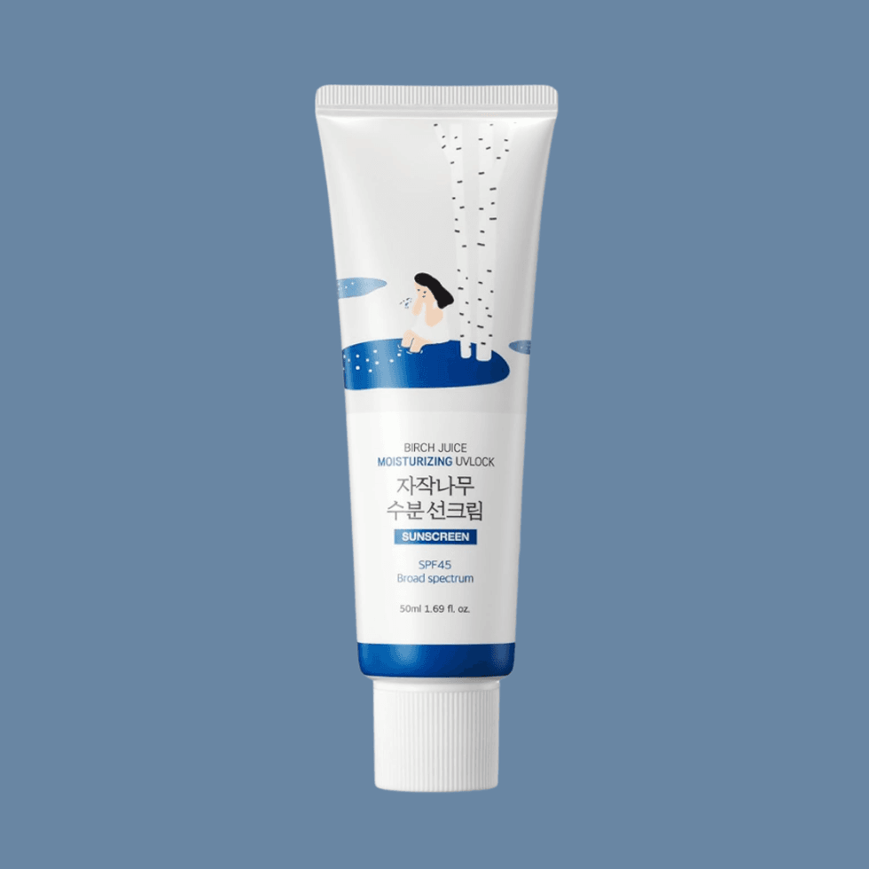 White sunscreen tube with birch tree design on a blue background.