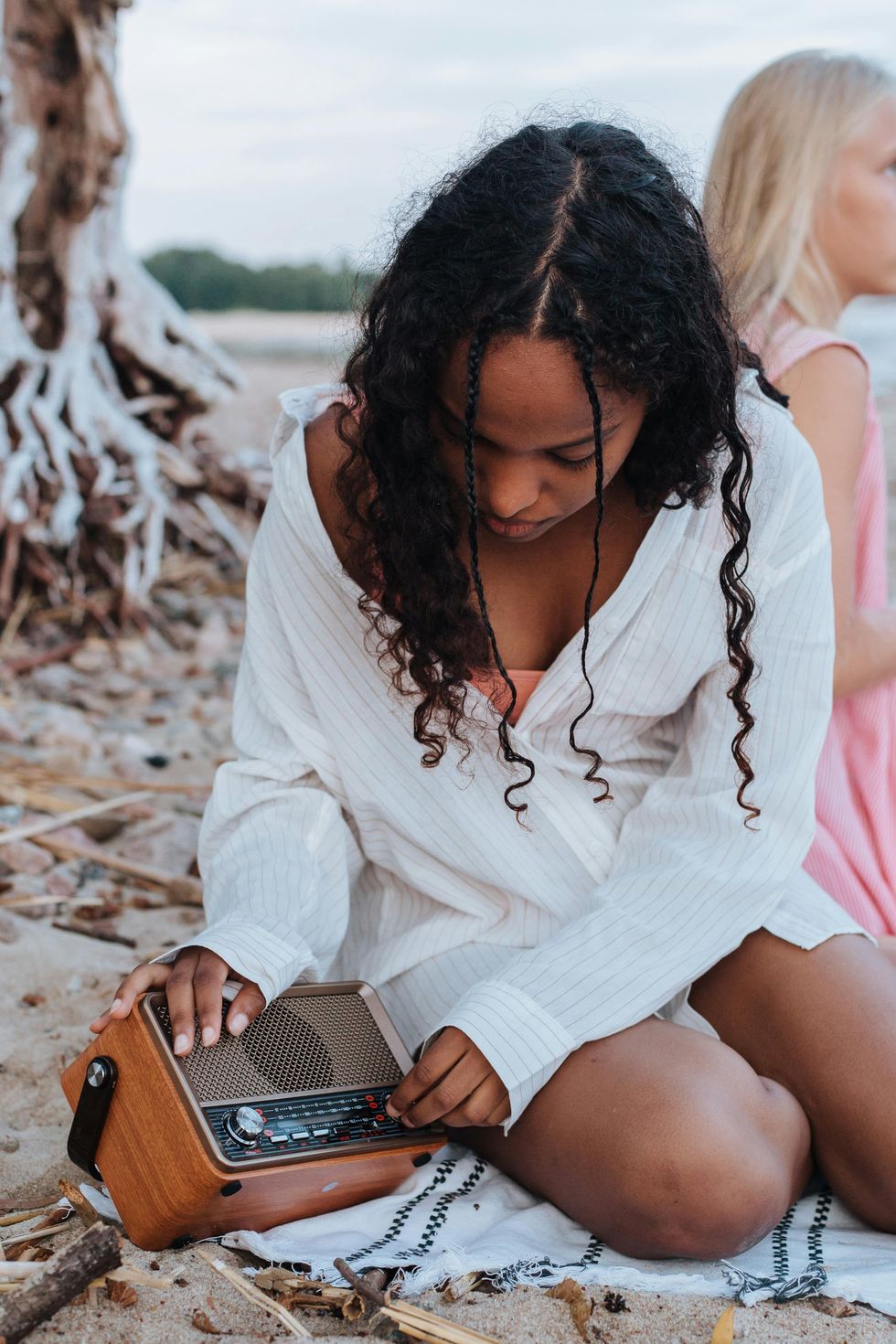 woman adjusting her speaker volume at the beach