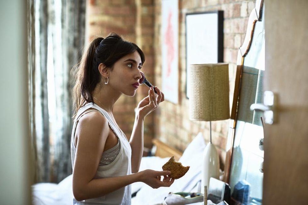 Woman applying face makeup. 