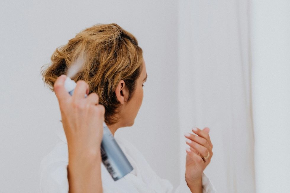 woman applying hair spray
