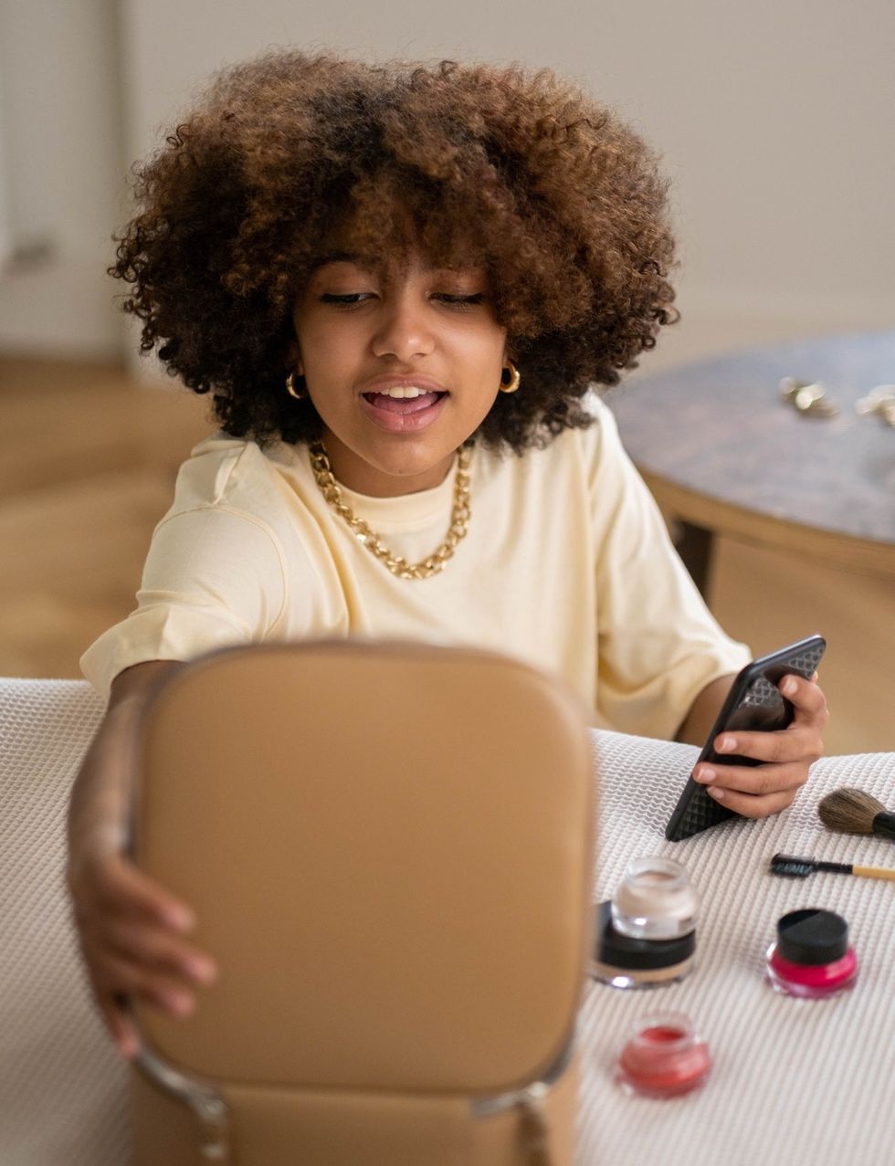 woman applying makeup from a brown makeup bag