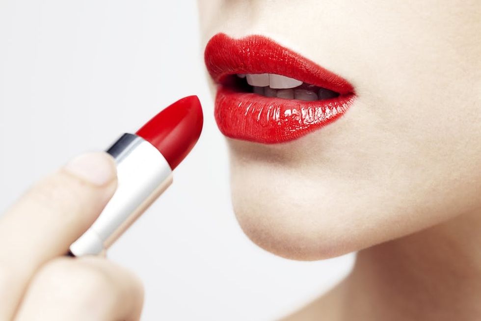 Woman applying red lipstick