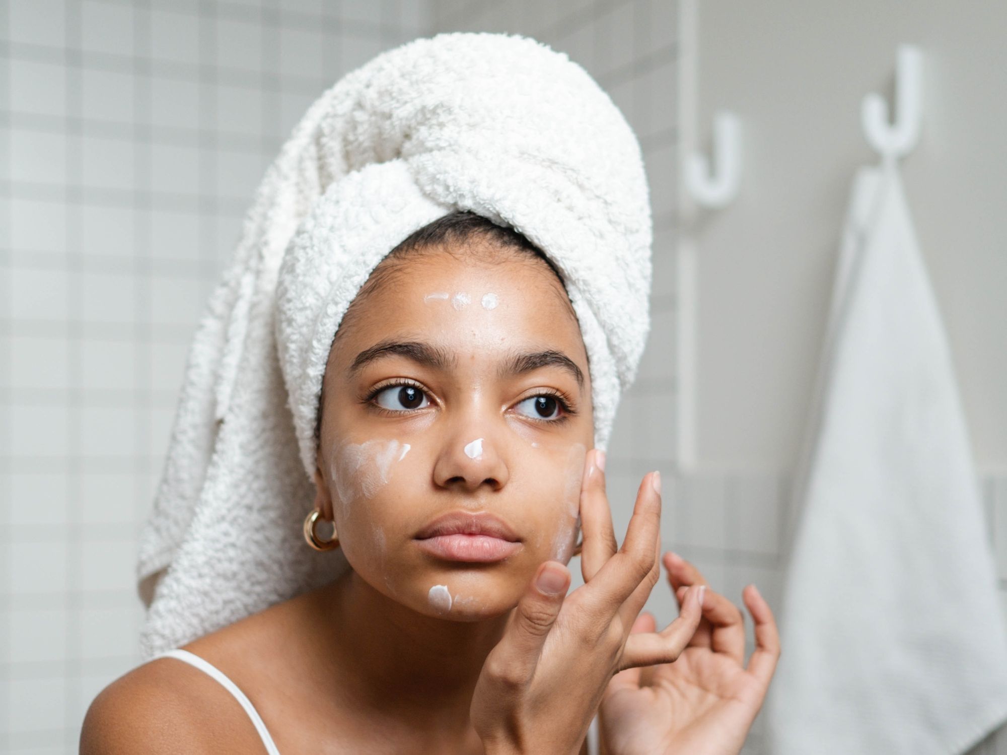 woman applying skincare product to her face