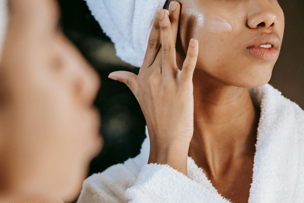 woman applying skincare to face