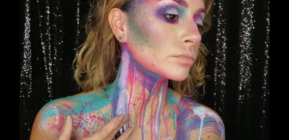 Woman applying splatter makeup to neck and chest. 