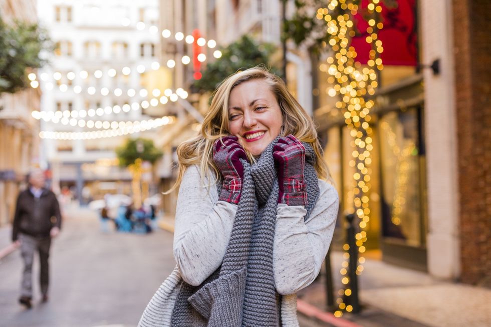 woman cheesing with twinkle lights in the background